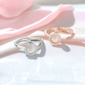 Silver and gold spinning rings on pink fabric