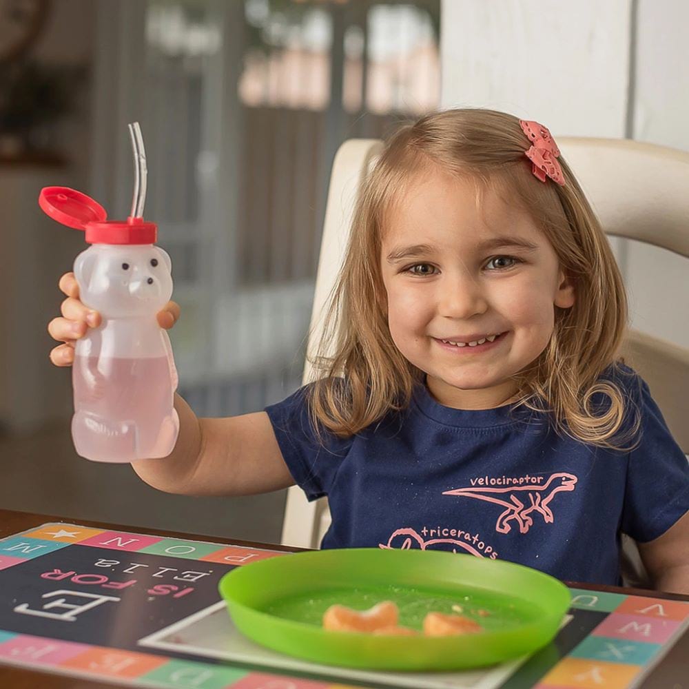 Cucasian girl smiling while holding Ark's juice bear cup with one hand BBU100New