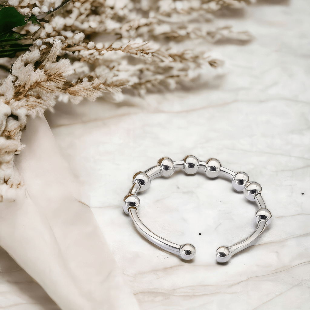 Adjustable ring on a marble countertop next to white flowers