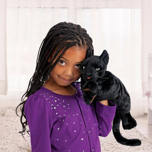 Afro american girl holding a black cat puppet from Folkmanis