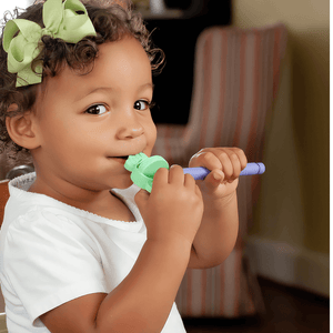 Afro american toddler girl biting a dog tip for the Z-Vibe