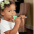 Afro american toddler girl biting a dog tip for the Z-Vibe