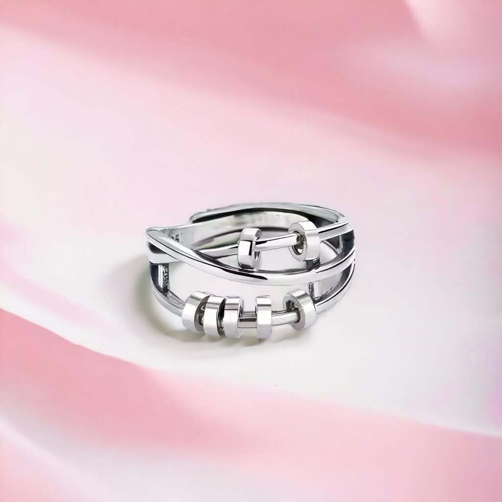 Anxiety ring with beads silver on pink fabric