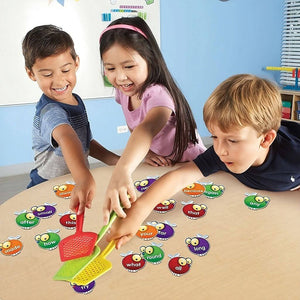 Asian girl and two caucasian boys playing Sight Words Swat game by Learning Resources at a light wood table