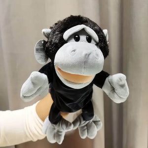 Baby chimpanzee hand puppet on woman's hand on grey background