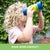 Blonde girl with curly hair looking through GeoSafari Kidnoculars by Educational Insights in a park