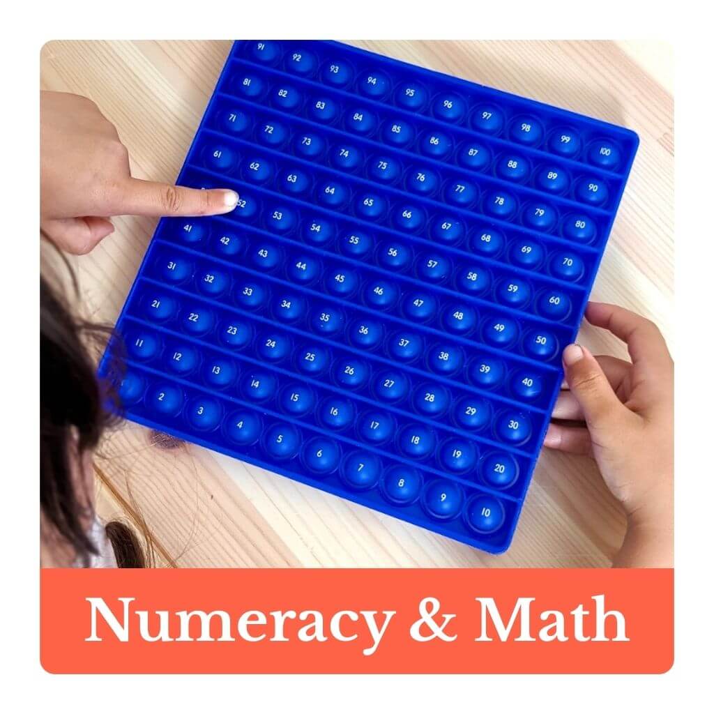 Blue bubble board with numbers held by hands on a wooden surface, labeled 'Numeracy & Math'.