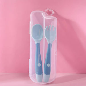 Blue-green bendable spoon and fork in a storage box on pink background