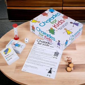 Box and contents of the Charades for Kids Board Game on a wooden table
