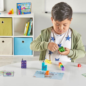 Boy building mathlink cubes numberblocks one to ten on a white table