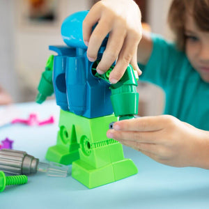 Boy constructing Design and Drill Robot by Educational Insights at a white table