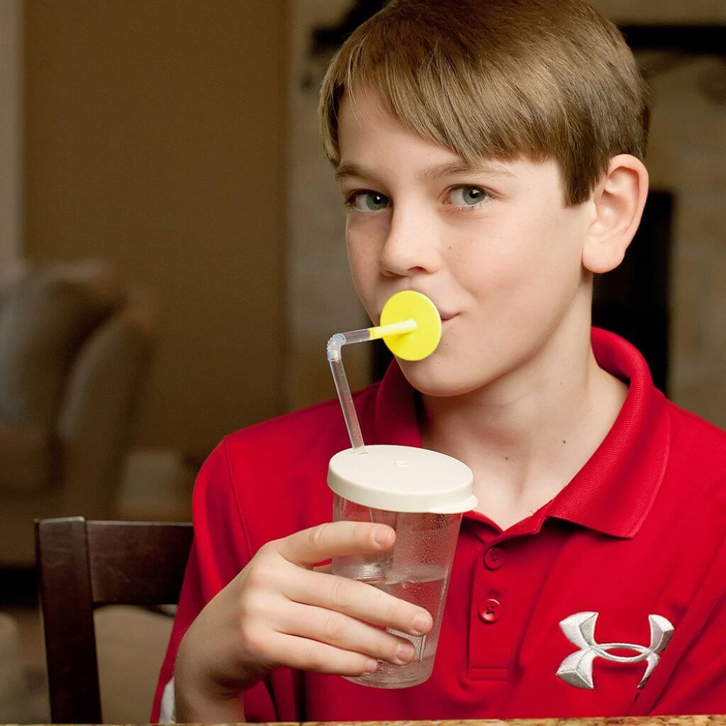 Boy drinking with a Ark lip blok long yellow