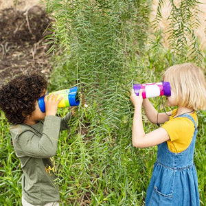 Boy and girl looking at green branches through GeoSafari Kidnoculars by Educational Insights