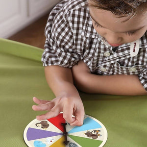 Boy playing The Sneaky, Snacky Squirrel Game! by Educational Insights on a green surface
