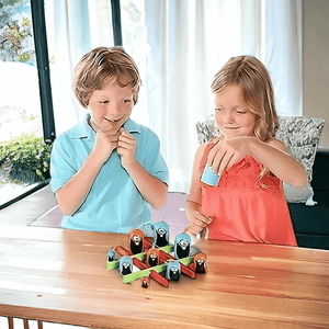 Caucasian boy and girl playing Gobblet Gobblers game by Blue Orange on a light wood table