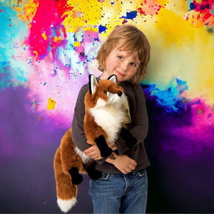 Caucasian boy holding a red fox puppet from Folkmanis on colored background