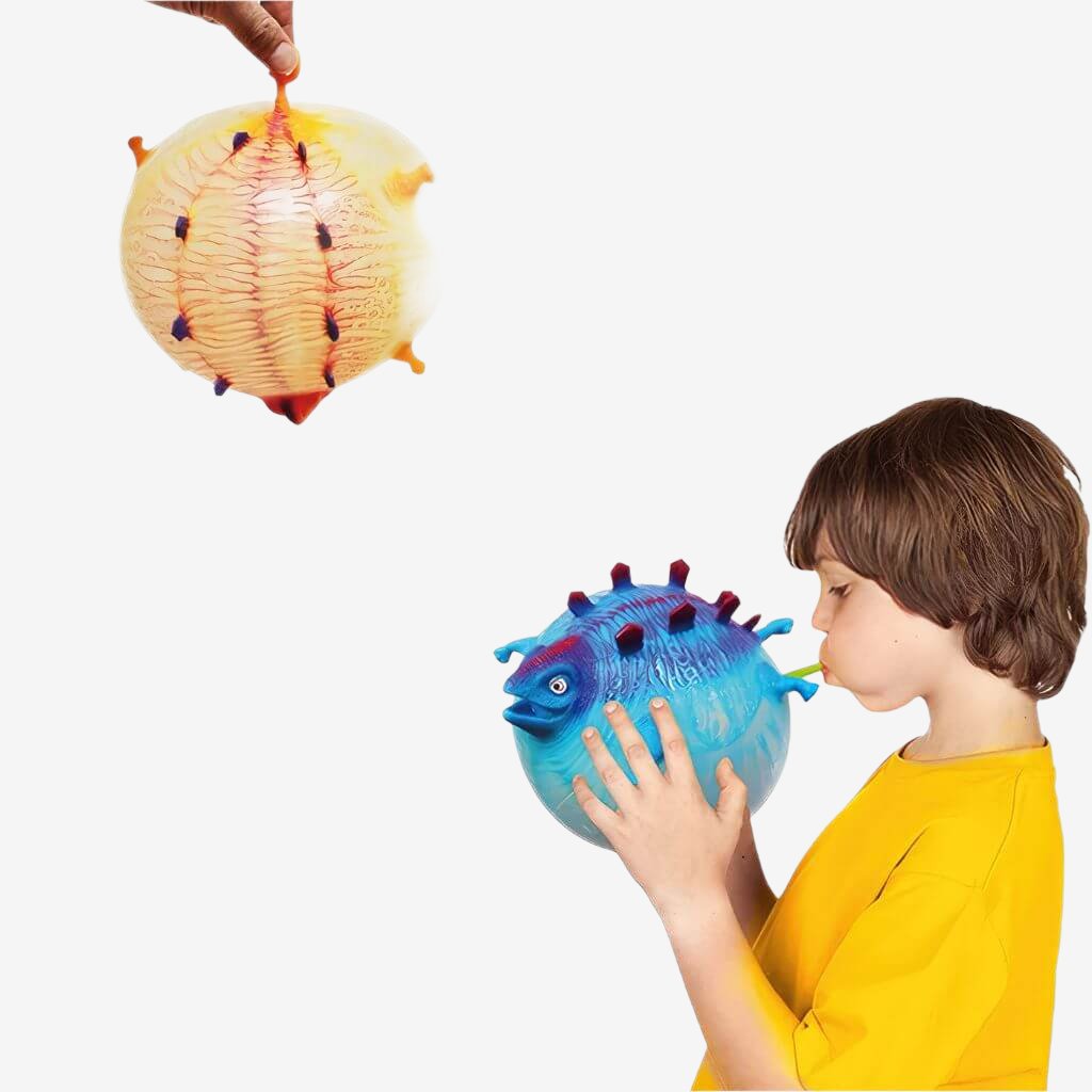Caucasian boy inflating a blue blow up animal on white background