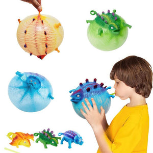 Caucasian boy inflating a blue blow up animal on white background