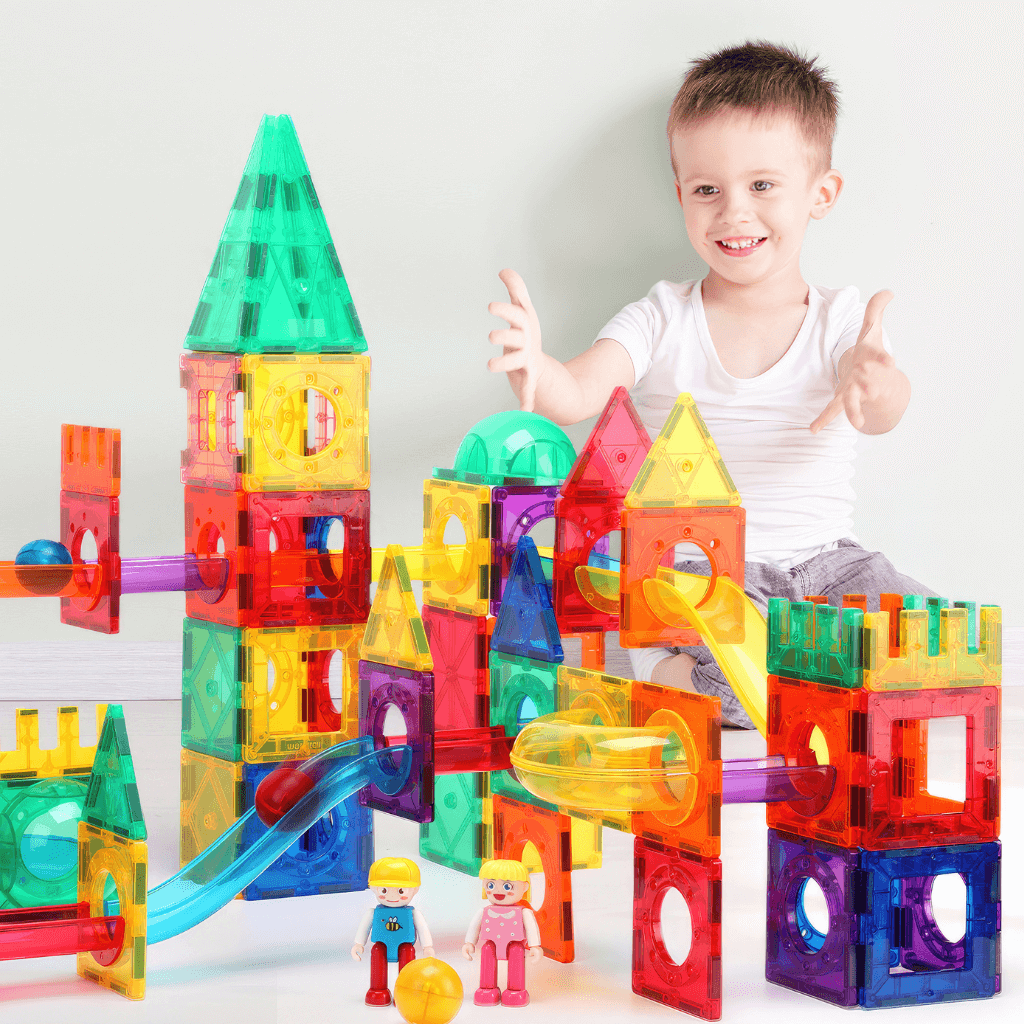 Caucasian boy playing with a magnetic tiles ball run