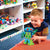 Caucasian boy playing with a Design and Drill Robot by Educational Insights on the floor in a toy store