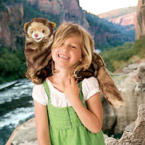 Caucasian girl carying a ferret hand puppet from Folkmanis on her shoulder