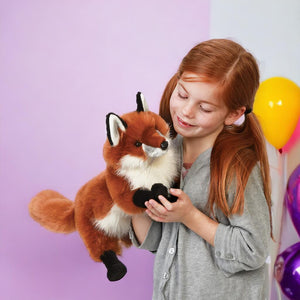 Caucasian girl holding a red fox puppet from Folkmanis on purple background with ballons