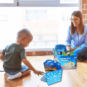 Caucasian mother and son playing barrier games  on the floor with ocean reusable sticker books