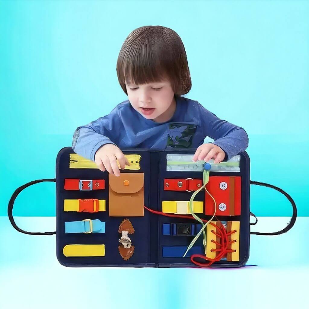 Caucasian toddler boy holding an open busy book on blue background