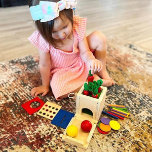 Caucasian toddler girl playing with a fine motor skills toy on the floor