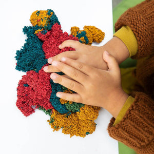 Child's hands playing with Playfoam® Naturals at a white table