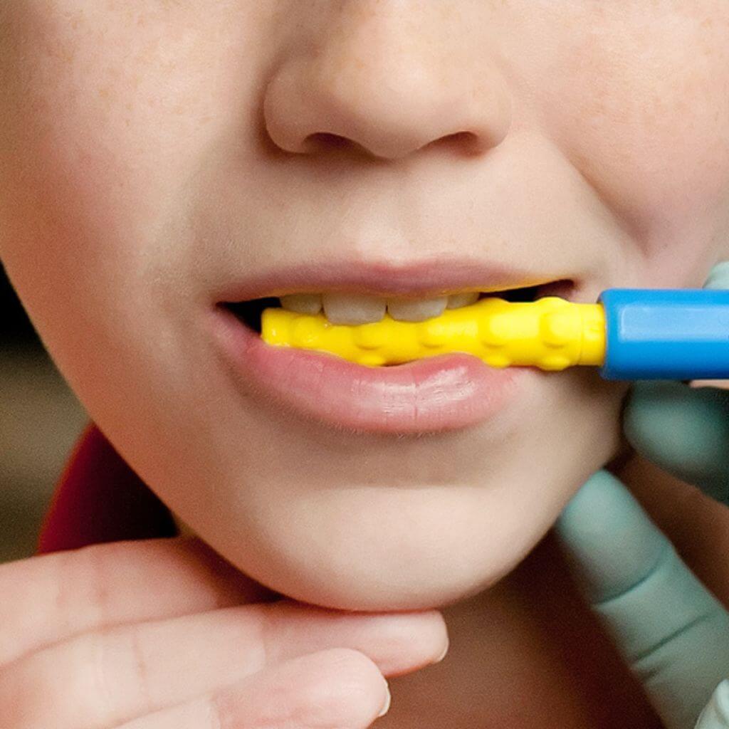 Close up of a boy biting an Ark Z-Vibe Textured Bite-n-Chew Tip XL 