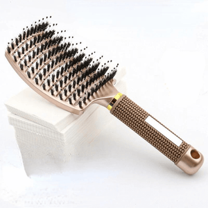 Detangling hair brush gold on a stack of white paper