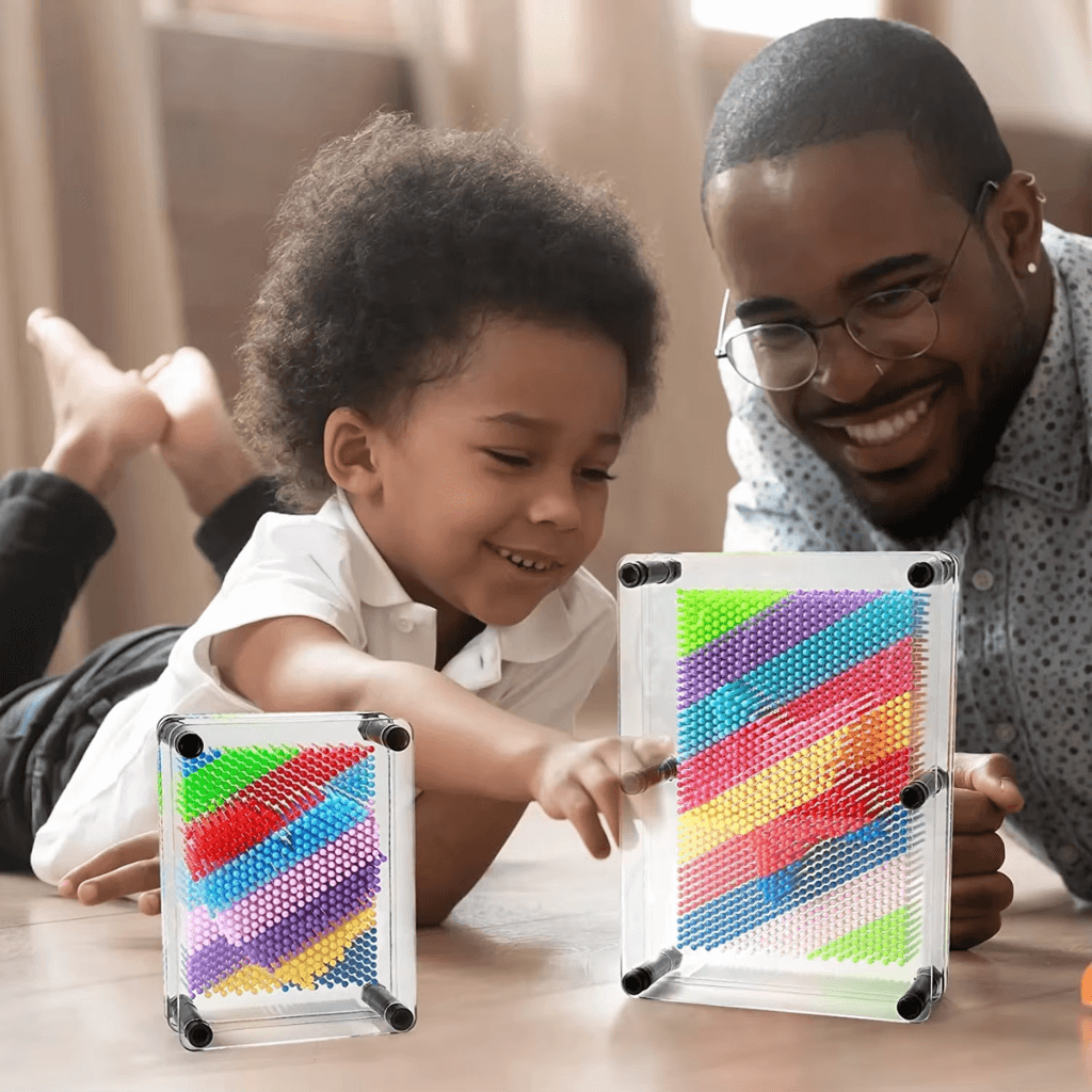Father and son playing with a Rainbow pin art
