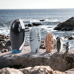 Five Russian nesting dolls on a rock side view with the sea in background