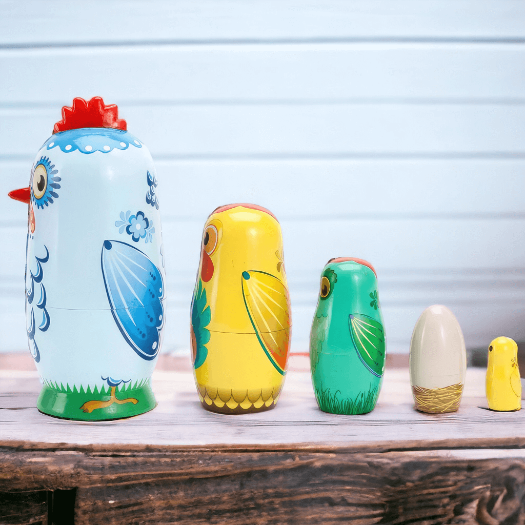 Five stacking dolls chickens on a wooden table side view