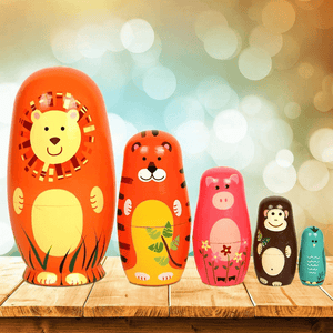 Five stacking dolls savanna animals on a wooden table with lights in background