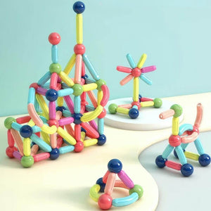 Four constructions made of magnetic toys with balls and rods on a white surface and blue background