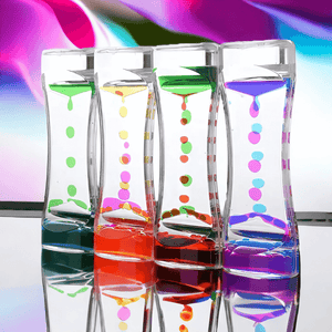 Four liquid timers on a mirrored surface and colored background