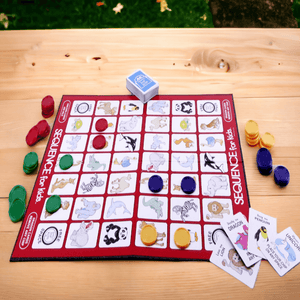 Game board, cards and chips from Sequence for Kids Game on a wooden table
