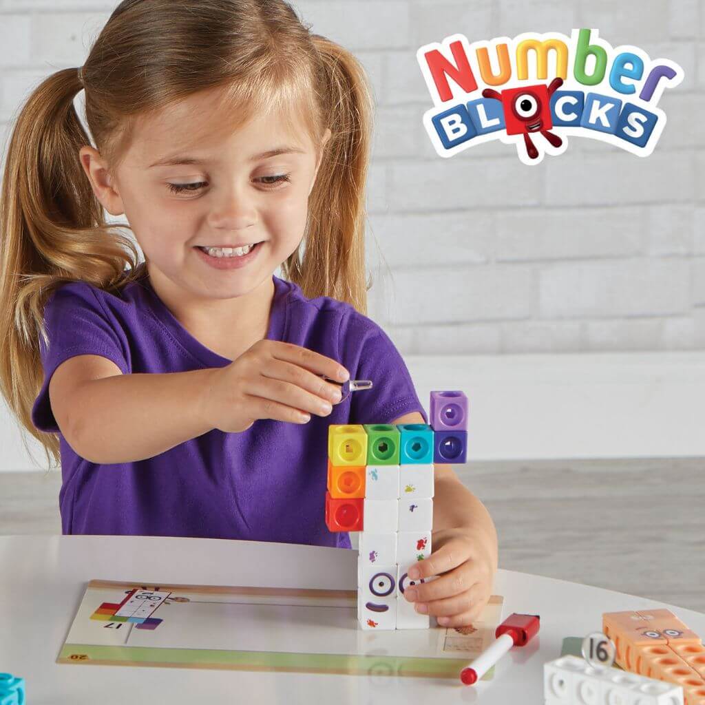 Girl building mathlink cubes numberblocks eleven to twenty on a white table