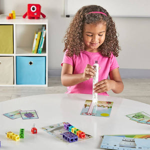 Girl with curly hair playing with mathlink cubes numberblocks one to ten activity set at a white-table