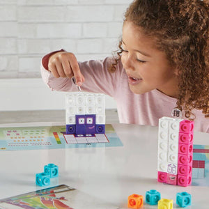Girl with curly hair playing with mathlink cubes numberblocks eleven to twenty activity set at a white table