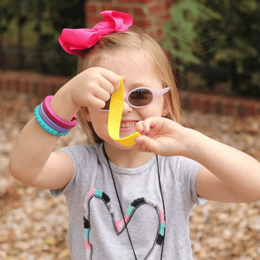 Girl playing with aa Ark sensory bookmark fidget yellow