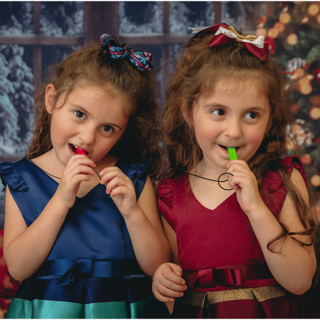 Girls chewing Krypto Bite necklaces by Ark