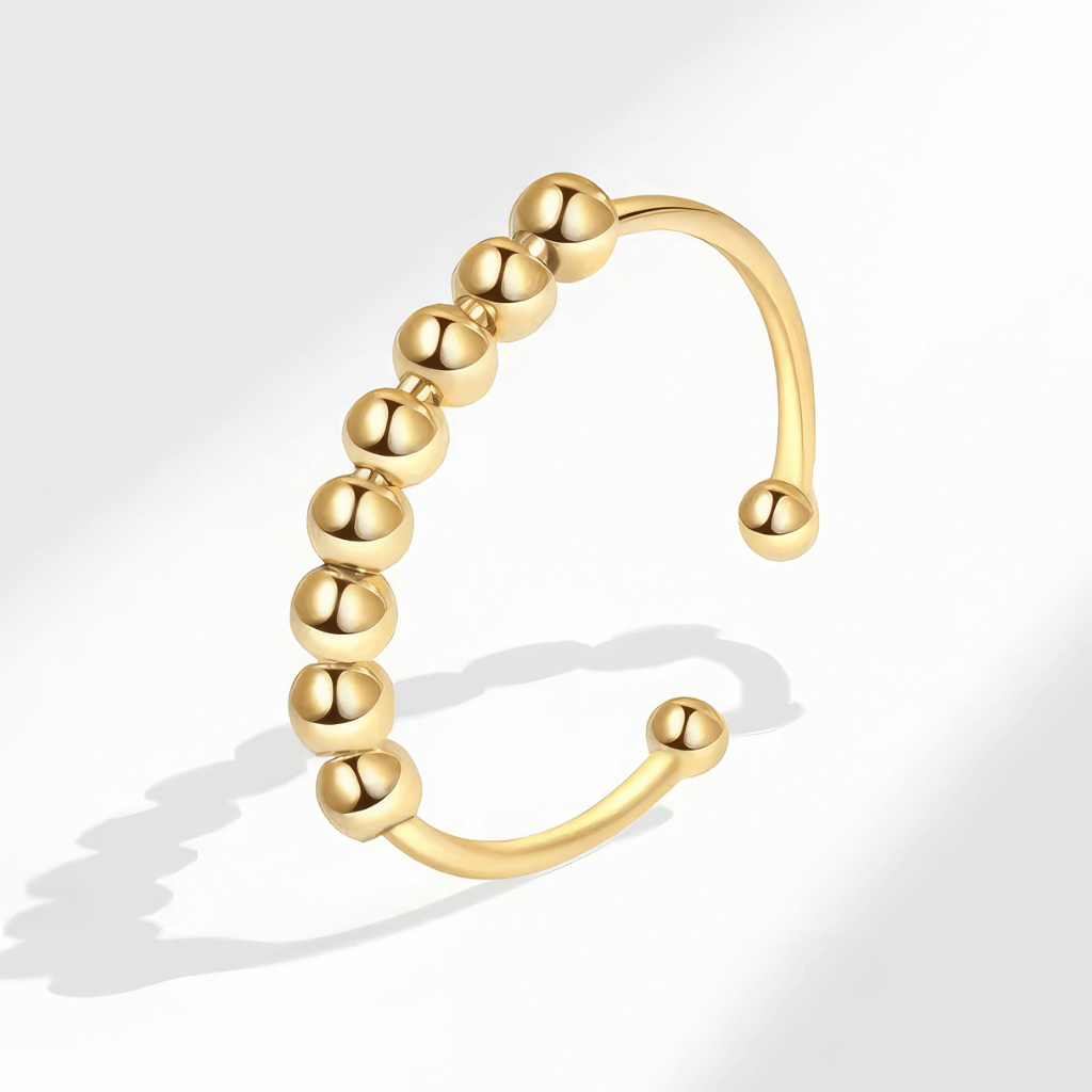 Gold plated adjustable silver fidget ring on grey background