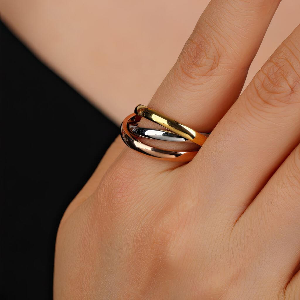 Gold and silver fidget ring on a finger against a neutral background