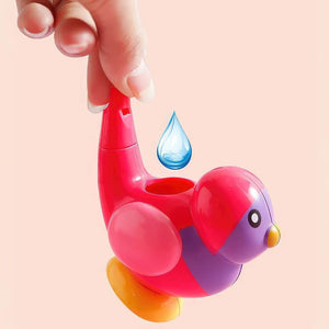 Hand holding a bird water whistle toy on peach background