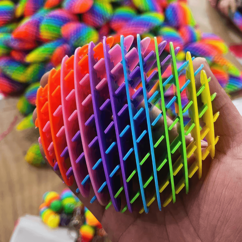 Hand holding a rainbow fidget worm