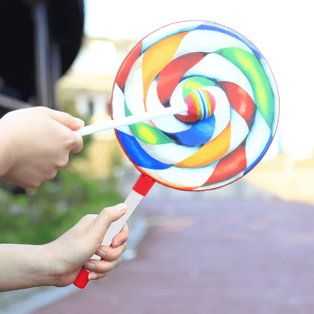 Hands beating a Lollipop drum on blurred background