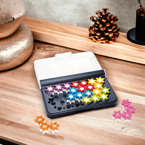 IQ Stars Travel Game by Smart Games on a light wood counter top